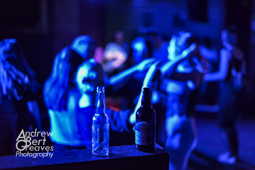 empty bottles in a club, people dancing in the background