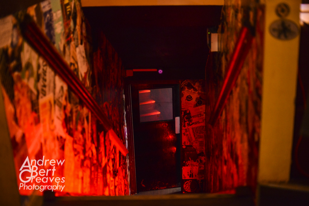 stairs leading down to the door of an underground club