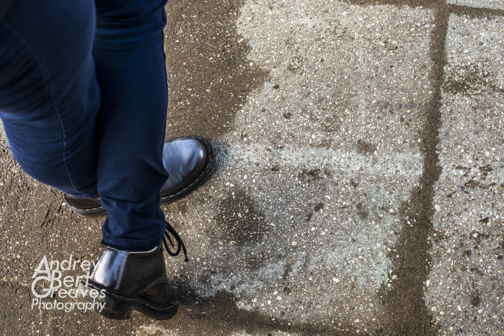 a woman's legs in blue jeans wearing shiny Dr. Martin boots