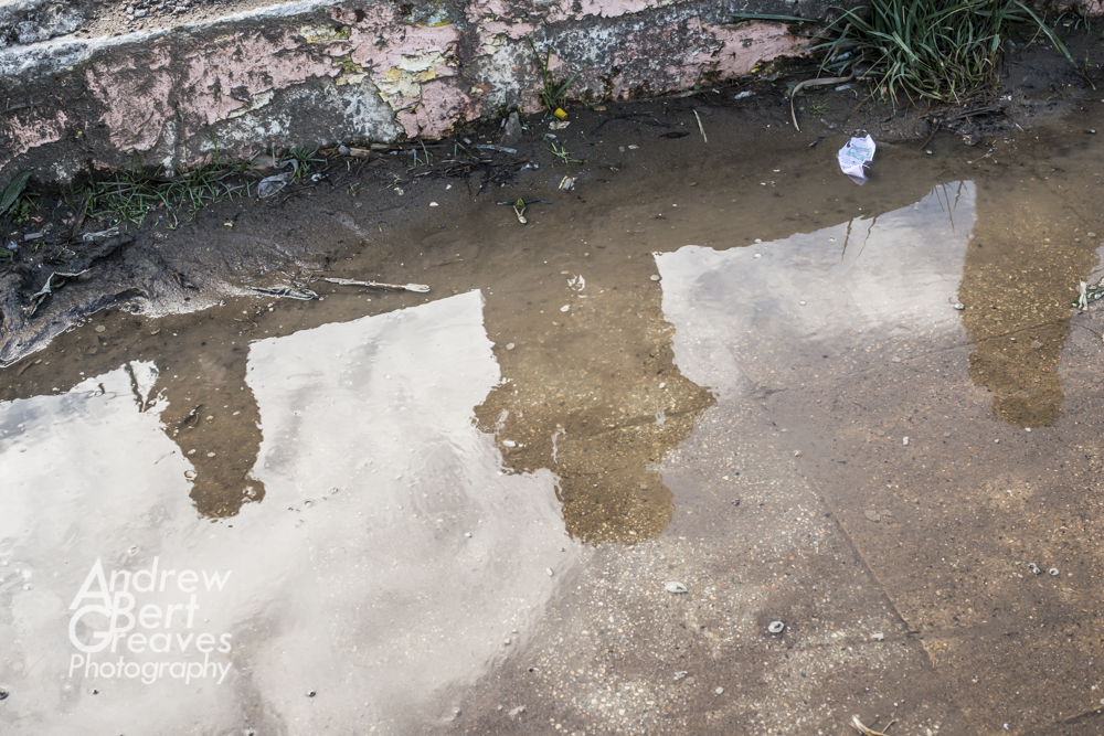 the reflections of people in a large puddle