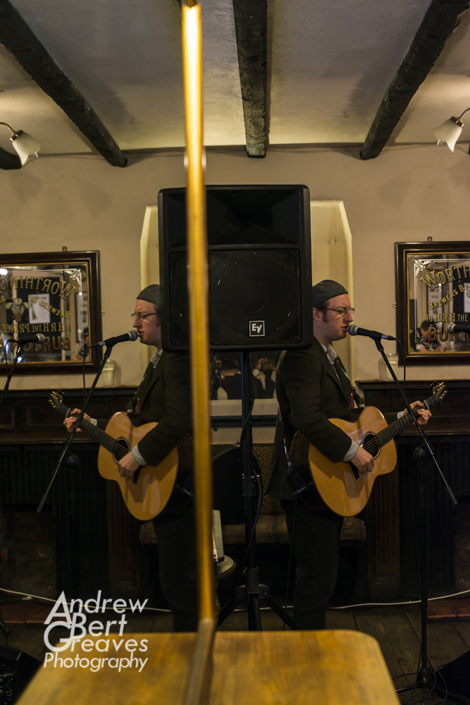 Phil Cooper reflected in a mirror as he plays guitar and sings at The Seven Stars in Bristol