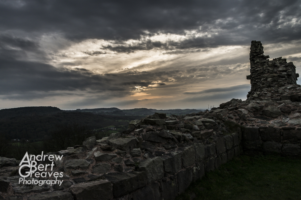 the ruined walls of Beeston castle under sunset skies